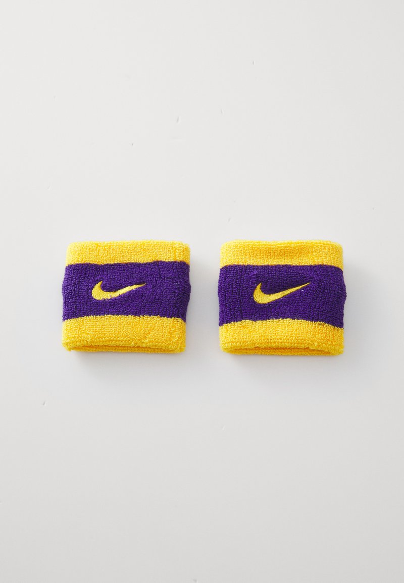 Nike wristbands in yellow and purple terry cloth, featuring a horizontal stripe design and embroidered logo in contrasting yellow.