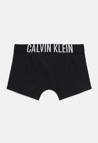 Svarte herreboxere med Calvin Klein-logo på livet, flatlagt på hvit bakgrunn, som viser framside og benåpninger.