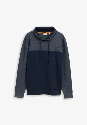 Granatowa bluza z zaokrąglonym kołnierzem, troczkami oraz dwukolorowym wzorem z jaśniejszym niebieskim panelem na górnej części klatki piersiowej.