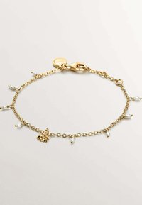 Pulsera de cadena de oro con acentos de perlas blancas y un charm decorativo de hoja. Incluye un cierre robusto para un cierre seguro.
