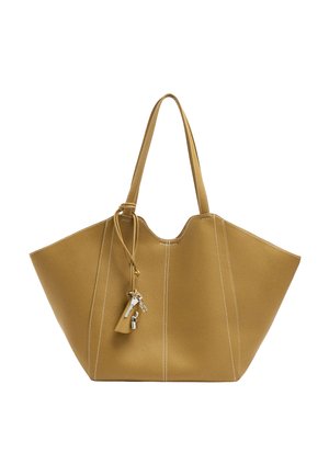 Musztardowożółta skórzana torba typu tote z białym przeszyciem, dwoma długimi uchwytami oraz breloczkami, w tym kluczami i małą kłódką.