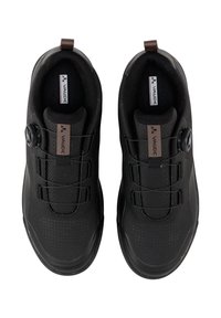 Des chaussures de sport noires avec une tige en maille, un bouton rond pour le serrage et des détails texturés, présentant un design minimal et une semelle intérieure douce.