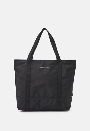 Czarna torba na ramię Tommy Jeans z dwoma uchwytami i małym logo umieszczonym na środku przodu na jednolitym białym tle.