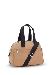 Lille beige håndtaske med sorte håndtag og en justerbar sort skulderrem, der har en frontlomme med lynlås og sølvhardware.