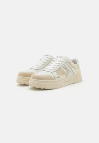 Sneaker con tomaia in pelle bianca, accenti in suede beige, dettagli perforati e una robusta suola in gomma color crema. Presentano lacci e branding.