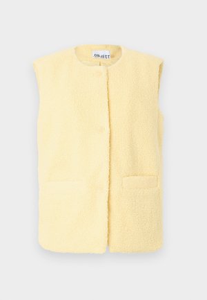 Flis brezrokavnik v mehki rumeni barvi z okroglim izrezom, sprednjo zapenjanje na gumbe in dvema stranskima žepoma; teksturirana površina dodaja vizualno zanimivost.