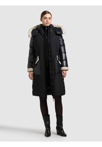 Zwarte donsjas met een capuchon gevoerd met nepbont, ritssluiting en knoopsluiting, zijzakken en geribbelde manchetten; knielang ontwerp met een glanzende afwerking.