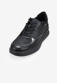 Baskets noires à lacets avec tige synthétique matelassée, accents de cuir texturé, bout arrondi et semelle en caoutchouc épaisse.