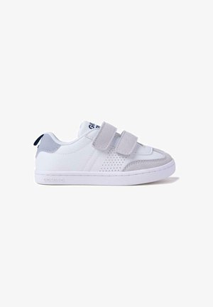 Baskets blanches avec des accents gris, dotées de sangles Velcro et d'un panneau texturé. La semelle est blanche avec une finition lisse et des perforations subtiles.