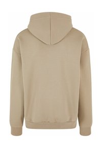 Sudadera con capucha beige, mezcla de algodón, puños y dobladillo acanalados, corte holgado, textura suave, detalle de costura central en la capucha.