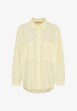 Løs, lysegul skjorte med knapper, to store frontlommer, lange ærmer og klassisk krave.