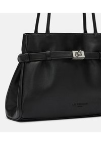 Czarna skórzana torebka o gładkiej teksturze, z akcentem w postaci srebrnego logo oraz strukturalnym designem. Posiada dwa uchwyty do noszenia.