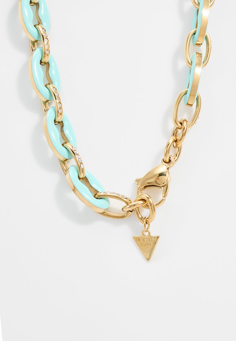 Goldkette mit hellblauen Gliedern, verziert mit Strasssteinen. Enthält ein dreieckiges Tag mit der Aufschrift "EDELSTAHL".