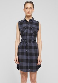 Košile-dress s krátkým rukávem, zapínání na knoflíky v černobílé kostkované vzoru, s dvěma náprsními kapsami a páskem v pase. Hladká tkanina, do kolen.