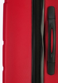 Maleta roja con un patrón texturizado, que presenta un cierre y asa negros. El diseño destaca un material estructurado y duradero.