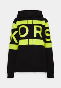 Sudadera negra con grandes rayas de neón amarillo y el texto "KORS". Incluye capucha con cordón y bolsillo canguro en la parte frontal. Textura de tela suave.