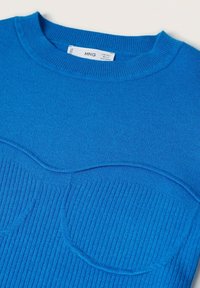 Pull tricoté bleu avec une texture côtelée et des accents circulaires en relief à l'avant. Encolure ronde classique et étiquette visible à l'intérieur.