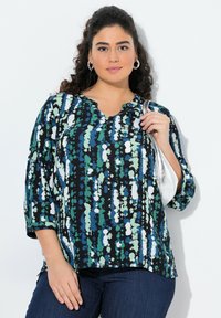Blusa nera con motivi astratti blu, verdi e bianchi. Presenta un collo a V e maniche a tre quarti. Tessuto morbido, vestibilità rilassata.