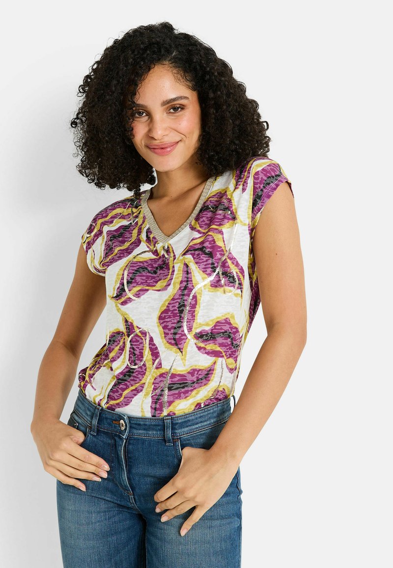 Blusa de flores de manga corta y escote en V con base blanca, que presenta patrones de hojas en púrpura, amarillo y rosa. Fabricada en una tela ligera y texturizada.