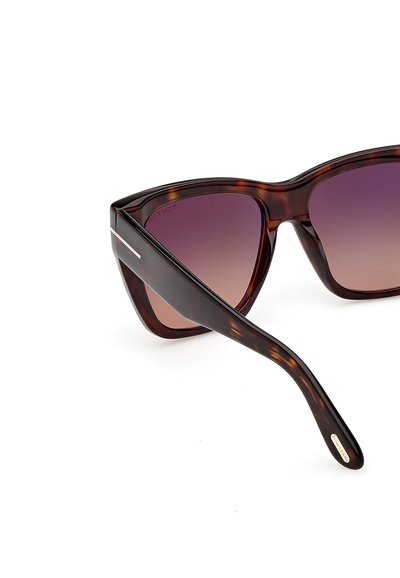 Gafas de sol de carey marrón con forma de ojo de gato, lentes degradadas en púrpura y un detalle dorado en la varilla.