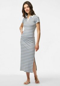 Svītrota polo kleita ar īsām piedurknēm, ar baltu apkakli un sānu traglēcēm. Krāsu palete ietver gaiši zilu, brūnu un baltu.