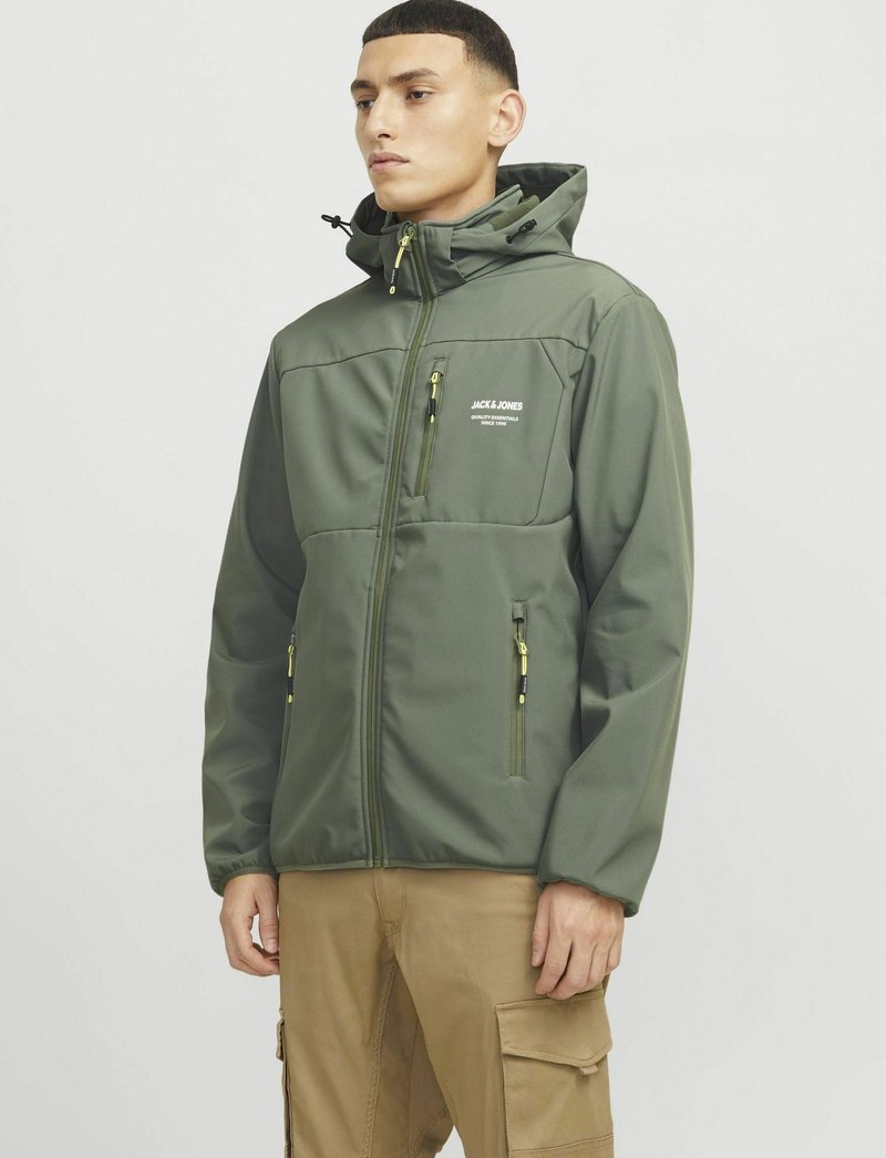 Groene zip-up jack met capuchon, voorzien van gele accenten, meerdere ritszakken en een glad, gestructureerd materiaal. Logo op de borst.