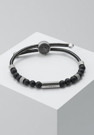 Bracciale nero caratterizzato da un design con perline, con pietre nere opache e accenti in argento, una chiusura a logo rotondo e una placca rettangolare "DIESEL".