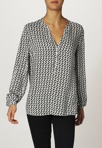 Bluzka z długim rękawem w czarno-białą kratkę houndstooth, z dekoltem w kształcie litery V i listwą guzikową, z marszczonymi mankietami dla dodatkowego efektu.