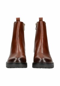 Par de botas de cuero marrón hasta el tobillo con suelas de goma negras y cremalleras laterales, mostradas de frente sobre un fondo blanco.