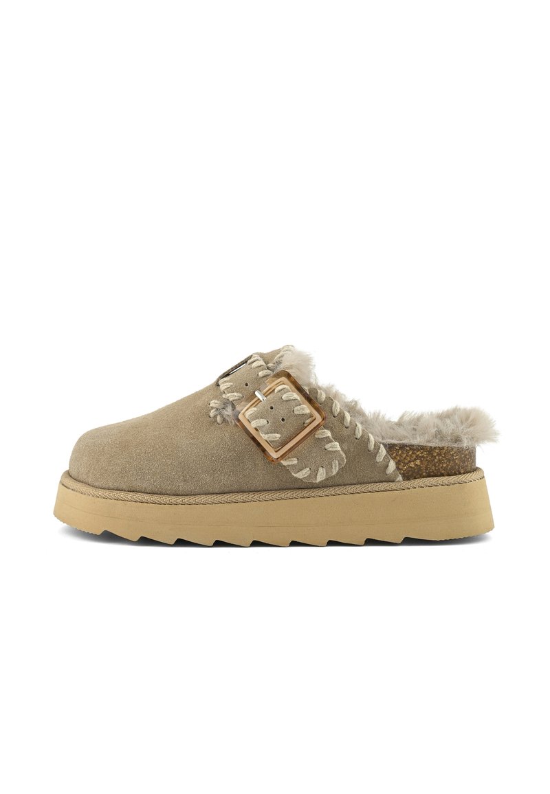 Bežani suede clogs s umetnim krznom, ukrašene dekorativnim šavovima i širokom trakicom s metalnom kopčom. Debeli gumeni đon s teksturom.
