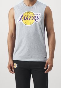Szara bezrękawnikowa koszulka z dużym purpurowym i żółtym logo "Los Angeles Lakers" z przodu. Miękki materiał z luźnym krojem.
