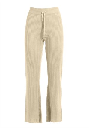 Ribbed beige pants with a drawstring waist, flared legs, and side slits at the hem, made from a soft, textured fabric.