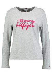 Szara koszulka z długim rękawem wykonana z bawełny, z okrągłym dekoltem, z czarnym i różowym logo "Tommy Hilfiger" nadrukowanym z przodu.