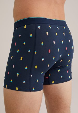 Boxers bleu marine avec des motifs colorés de cônes de glace et de sucettes glacées, taille élastique et texture en coton doux.