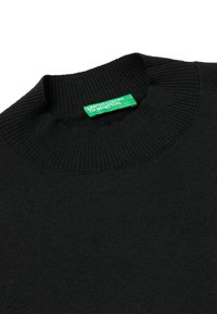 Maglione nero lavorato a maglia con scollo a coste. Presenta un'etichetta verde "United Colors of Benetton". Tessuto morbido, senza motivi o accenti visibili.