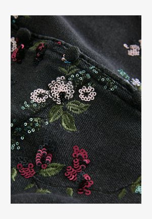 Must mustril, mille lilledega, mis on broderitud roosa, valge ja rohelise värviga, kaetud erinevate värvide sädelustega ja tekstureeritud pinnaga.