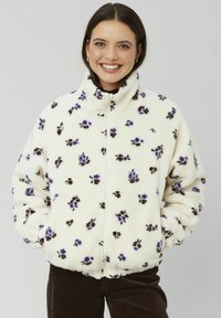 Veste en polaire crème avec imprimé floral violet et marron, col haut, fermeture éclair, et poignets et ourlet élastiques pour un ajustement parfait.