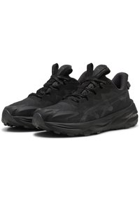 Des chaussures de sport noires avec un dessus texturé et respirant, dotées d'une semelle robuste, d'un design à lacets et de accents de marque subtils.