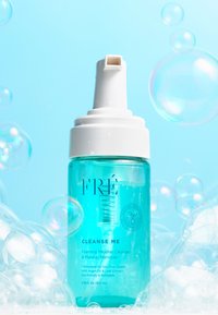 Heldere blauwe plastic fles met een witte pomp. Het etiket zegt "CLEANSE ME Foamende Micellaire Reiniger & Makeup Verwijderaar." Bubbels omringen het.