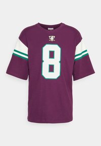 Camiseta de manga corta morada con un gran número 8 en blanco, acentos de rayas verdes y blancas en las mangas y un logo bordado arriba.