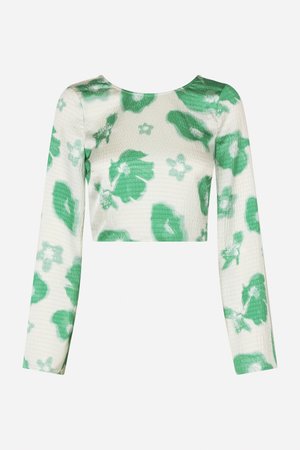 Top corto de manga larga con patrón floral verde, hecho de una tela texturizada y ligera. Escote redondo, diseño ajustado, textura suave.
