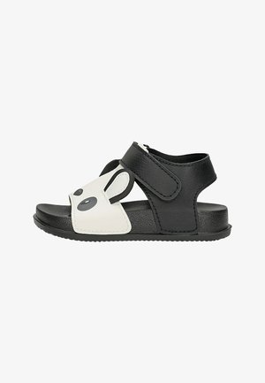 Sandale pour tout-petit noire et blanche avec motif visage de panda, bride ajustable et semelle texturée pour un maintien sûr et un confort optimal.