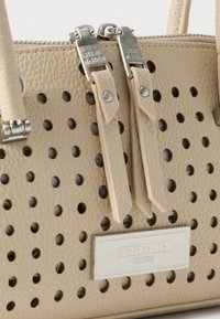 Τσάντα χειρός από μπεζ δέρμα με διατρητικές οπές, διπλά ασημένια φερμουάρ και ορθογώνια μεταλλική πλακέτα με το λογότυπο "Steve Madden New York".