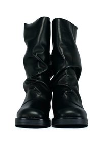 Stivali in pelle neri a metà polpaccio con un design morbido, punte arrotondate e suole in gomma piane, mostrati frontalmente su uno sfondo bianco.