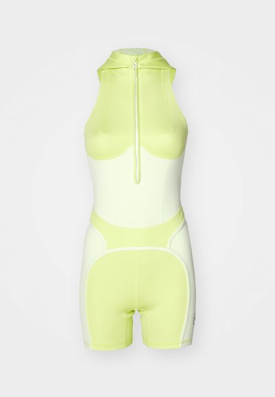 Mono con cuello halter en amarillo neón y blanco, con cremallera frontal y diseño ajustado con costuras acentuadas y pantalones cortos.