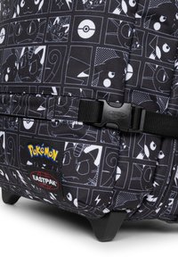 Svart tygryggsäck med vita Pokémon-karaktärstryck, rutmönster och svarta remmar. Inkluderar Eastpak- och Pokémon-logotyper.