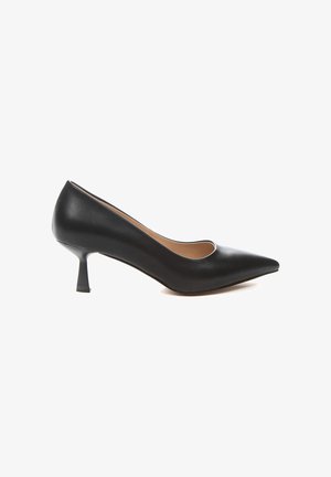 Zapato de tacón negro de cuero con puntera afilada, corte curvado en la parte superior y tacón medio y afilado. Textura suave en toda la superficie.