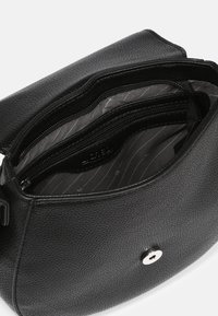 Schwarze Ledertasche mit strukturierten Oberflächen, Reißverschlusstaschen und einem gemusterten Innenfutter. Mit silbernem Druckknopfverschluss.