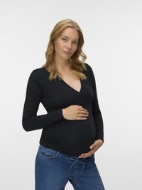 Must pikkade varrukatega rasedate top, millel on mähise disain, kombineeritud siniste teksadega, millel on nöörvöökoht. Siidine tekstuur, keha järgnev siluett.