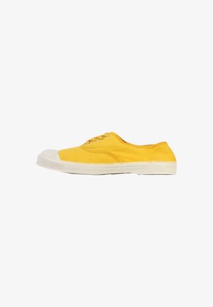 Zapatilla de lona amarilla con puntera y suela de goma blanca, vista de lado sobre un fondo blanco.